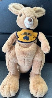 Plush kangaroo toy wearing an Australia shirt on a dark background